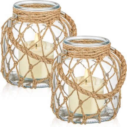 Two clear glass nautical lanterns with jute rope handles and flickering LED candles inside, on a tabletop.