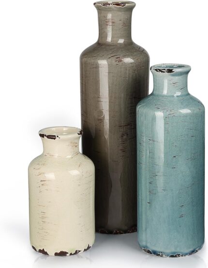Set of three CUCUMI ceramic vases in distressed morandi colors, displayed on a shelf, showcasing rustic and coastal style.