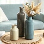 Set of three CUCUMI ceramic vases in distressed morandi colors, displayed on a shelf, showcasing rustic and coastal style.