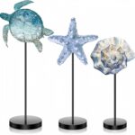 Three wooden tabletop signs in blue featuring a starfish, sea turtle, and shell, standing on individual bases.