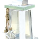 A white and blue wooden lantern candle holder with nautical ropes and a starfish, sitting on a surface.