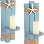 Two blue wooden starfish wall candle sconces with hemp rope accents, holding small candles, mounted against a light wall.