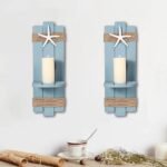 Two blue wooden starfish wall candle sconces with hemp rope accents, holding small candles, mounted against a light wall.