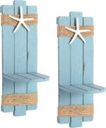Two blue wooden starfish wall candle sconces with hemp rope accents, holding small candles, mounted against a light wall.